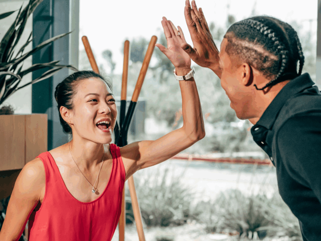 Two professionals celebrating a successful client intake process after improving their client intake form and workflow.