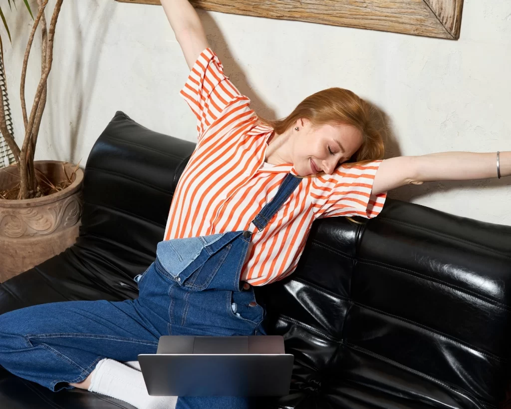 woman in blue overalls and an orange shirt celebrates representing the relief and success that comes from niching down